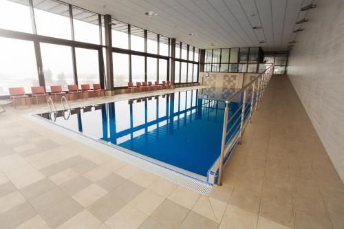 ein großer Pool in einem Gebäude mit Fenstern in der Unterkunft Apartmány pri vstupe do Aquaparku in Senec