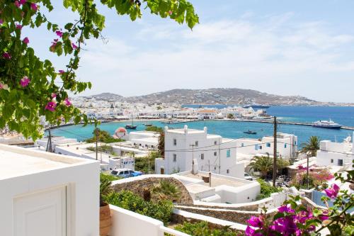 a view of a town with white buildings and the ocean at Anchor Αpartments in Mýkonos City