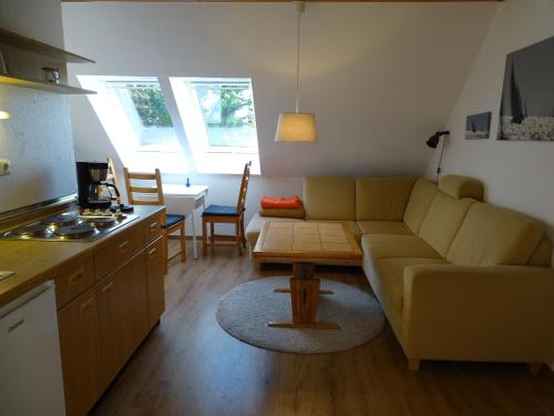 salon z kanapą i stołem w obiekcie Der Ferienhof am Meer w mieście Fehmarn