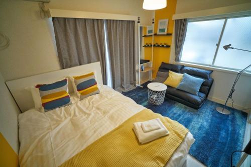 Un dormitorio con una cama grande y un sofá. en RHK guest house, en Tokio