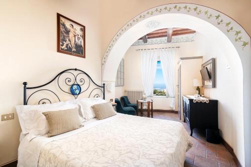 1 dormitorio con 1 cama grande y un arco en Albergo Il Giglio, en Montalcino