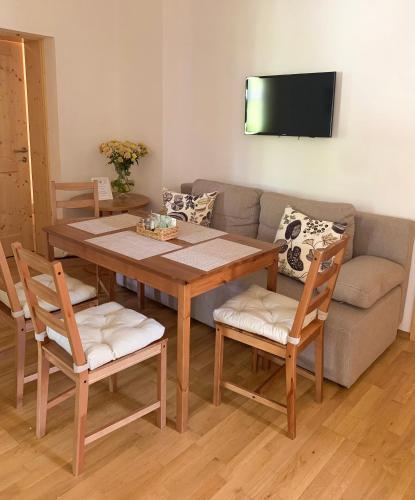 a living room with a table and chairs and a couch at Der Ulmenhof in Gosau