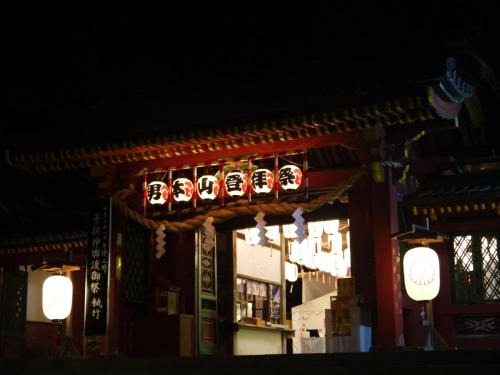 a building with chinese signs on it at night at Okunikko Guesthouse JUN in Nikko