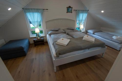 a bedroom with a bed and a chair and two windows at Chalet 164 in Bad Goisern
