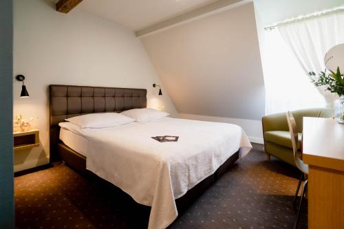 a hotel room with a bed and a window at Hotel Czarna Róża in Toruń