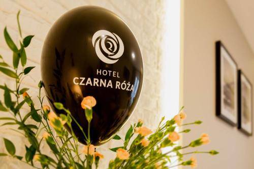 a black balloon is sitting next to a plant at Hotel Czarna Róża in Toruń