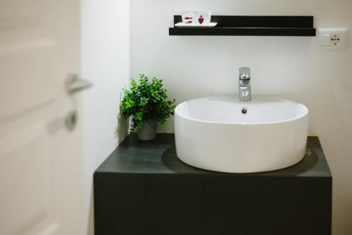 baño con lavabo blanco en una encimera negra en Agatha Cosy Hotel, en Catania