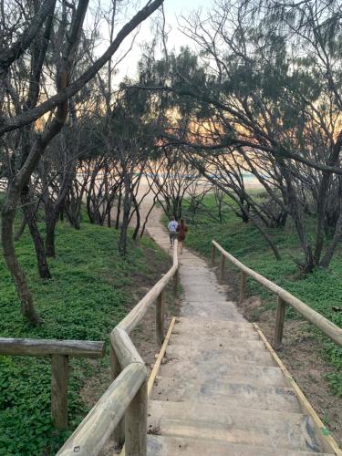a person walking on a path in a field at Aqua Promenade Beachfront Holiday Apartments in Sunrise Beach