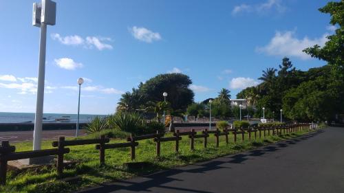 a fence on the side of a road near the beach at Appartement Blue Coast in Mahébourg