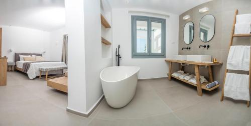 a white bathroom with a tub and a sink at Oro Suites in Kinion