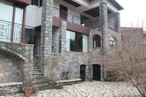 a large stone building with windows and a balcony at Elati's traditional and cosy home in Eláti