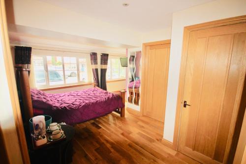 een slaapkamer met een paars bed en een raam bij Dreamhaven in Dunbar