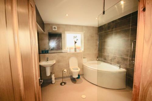 uma casa de banho com uma banheira, um WC e um lavatório. em Dreamhaven em Dunbar