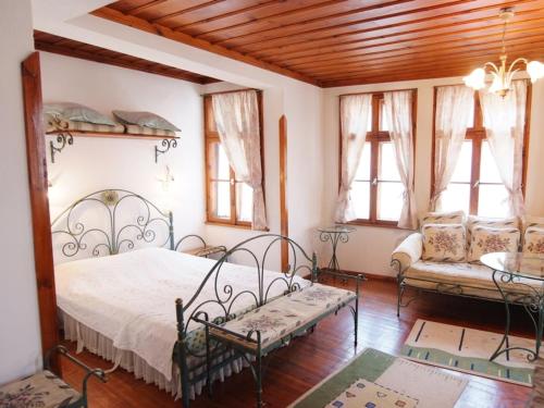 una camera con letto, divano e finestre di Despot Slav Hotel & Restaurant a Melnik