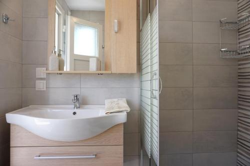 a bathroom with a white sink and a mirror at Volada Your View in Apérion