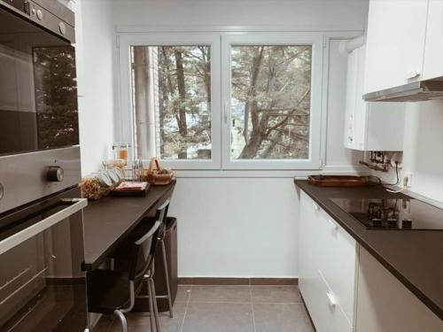 eine Küche mit einer Theke und einem großen Fenster in der Unterkunft Piso acogedor y tranquilo - Junto a ifema y aerop. in Madrid