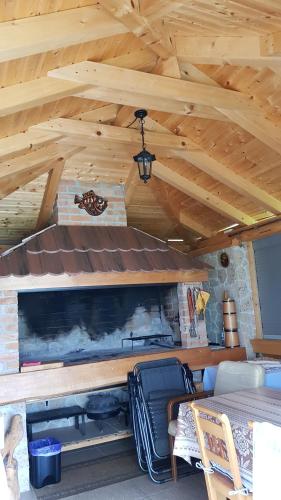 a living room with a fireplace and a wooden ceiling at Guest House Adrijana in Seliste Dreznicko