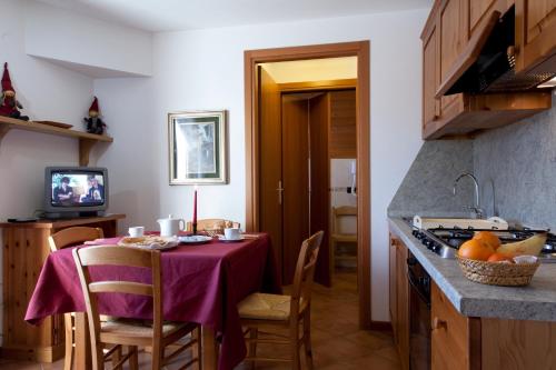 une cuisine avec une table et un chiffon violet dans l'établissement Residence Cavallino, à Ponte di Legno