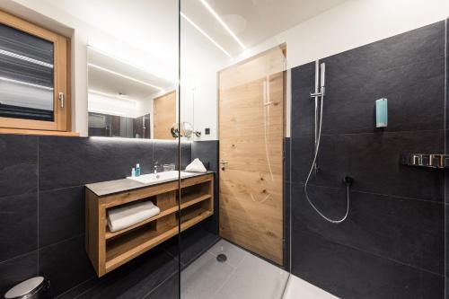 y baño con ducha y lavamanos. en Weingut Moser Apartments, en Caldaro