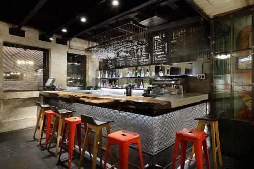 a bar with orange stools in a restaurant at Hotel The Public - Special Category in Istanbul