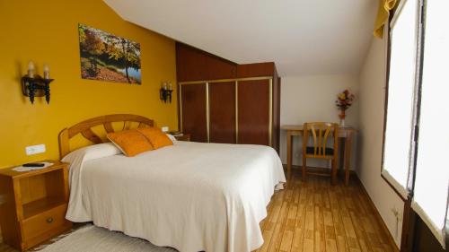 a bedroom with a white bed and a yellow wall at Tolare-Berri in Zestoa