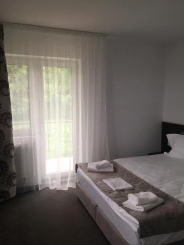 a bedroom with a bed and a window with towels at IOANA - camere de inchiriat in Mangalia