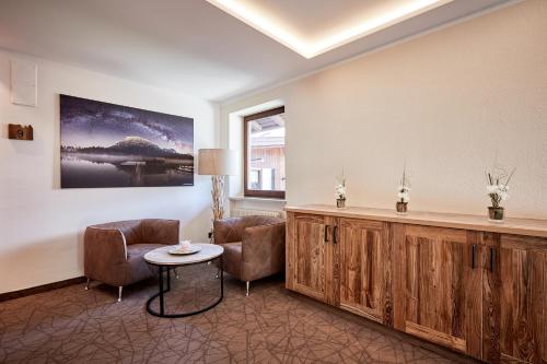 a waiting room with chairs and a table and a painting at Hotel Garni Savoy - new opening in Castelrotto