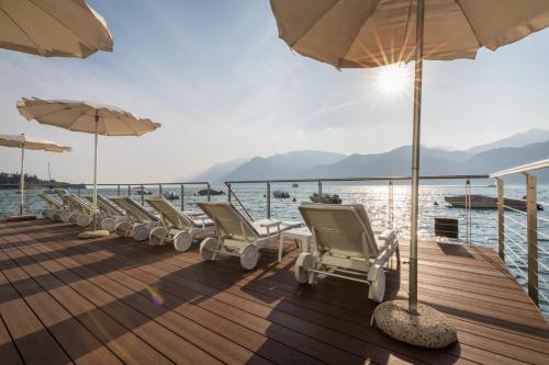 a row of chairs and umbrellas on a boat at Hotel Vega in Malcesine