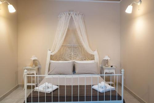una camera da letto con un letto bianco con baldacchino di Villa Erminia a Canicattini Bagni