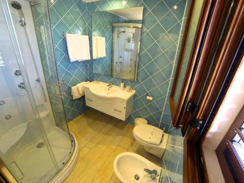 e bagno con servizi igienici, lavandino e doccia. di Domus De Janas Sul Mare a Bari Sardo