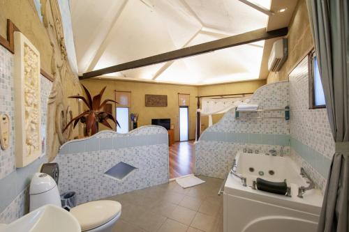 a bathroom with a tub and a toilet and a sink at Pancala Vacation Inn in Nanwan