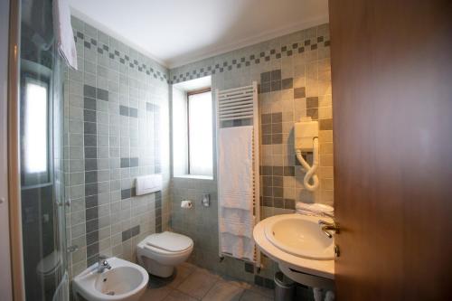 a bathroom with a toilet and a sink at Hotel Giardino in Cannobio