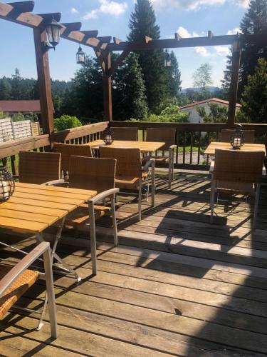 a group of tables and chairs on a wooden deck at Berghotel HARZ in Hahnenklee-Bockswiese