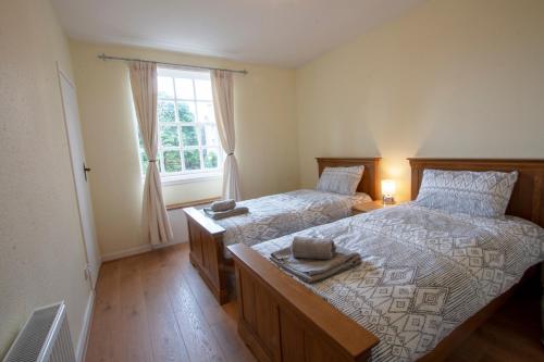 a bedroom with two beds and a window at Cadell House Apt - Royal Mile in Edinburgh