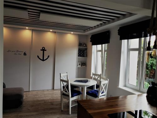 a dining room with a table and chairs and an anchor on the wall at Apartament 200m do plaży in Gdańsk