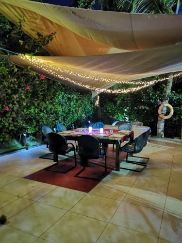 a table and chairs under a tent with lights at Red Mango Hotel and Apartments in Takoradi