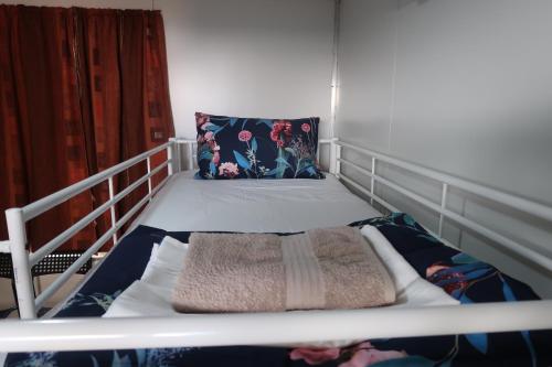 a white bed with a pillow and a blanket at Mud Crab Motel in Derby