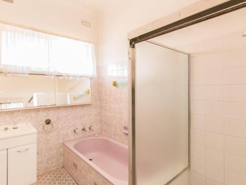 a bathroom with a bath tub and a sink at 11 Peel Street in Tuncurry