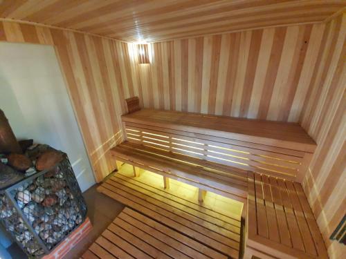 an empty sauna with a bench in a room at UpeNes in Lubāna