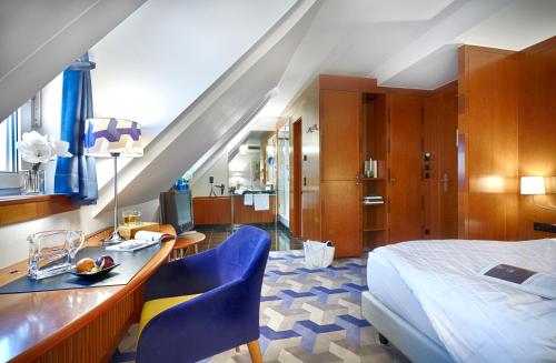 - une chambre avec un lit, une table et des chaises dans l'établissement Seaside Park Hotel Leipzig, à Leipzig