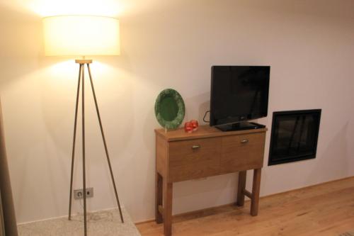 a room with a television on a dresser with a lamp at Quinta de Fiães in Vilar de Maçada