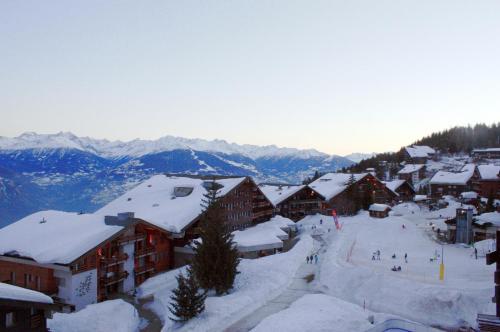 a ski resort with snow covered roofs and buildings at Apartment in Anzère in Anzère