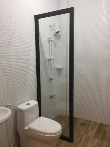 a bathroom with a shower with a toilet and a sink at Hollywood Suites in General Santos