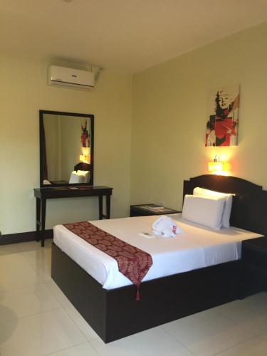 a bedroom with a large bed and a mirror at Hollywood Suites in General Santos