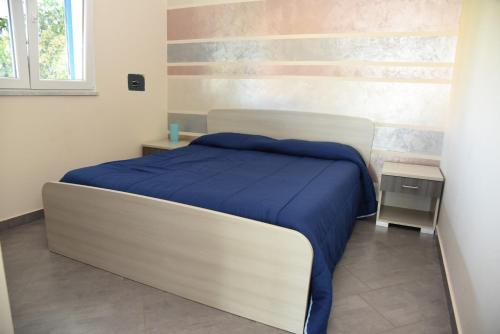 a bedroom with a bed with a blue blanket at Villa Letizia in Campofelice di Roccella