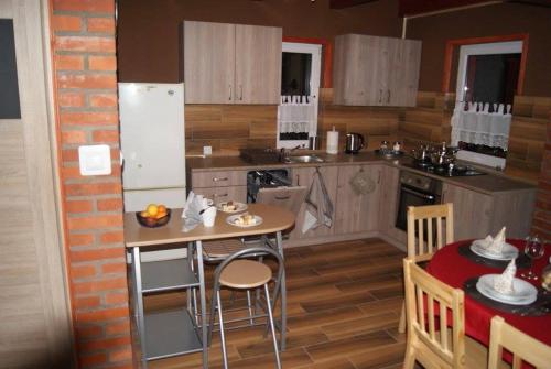 cocina con mesa y nevera en Domek Całoroczny OSTOJA en Istebna