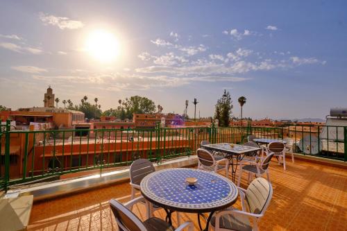 eine Terrasse mit Tischen und Stühlen auf dem Balkon in der Unterkunft Hotel Central Palace in Marrakesch