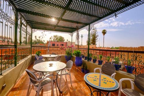 a patio with tables and chairs on a balcony at Hotel Central Palace in Marrakesh