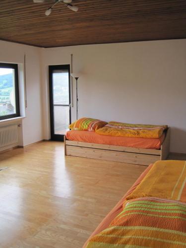 two beds in a room with two windows at Villa-Fuldablick in Morschen