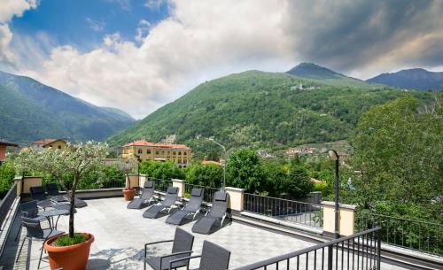 a balcony with chairs and a view of mountains at Hotel Giardino in Cannobio